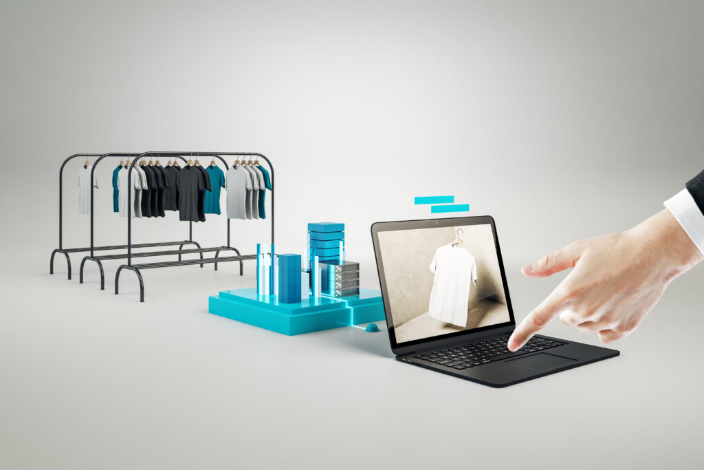 Creative Online Shopping Concept With Hand Pointing At Huge Laptop And Racks With Clothes