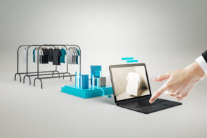 Creative Online Shopping Concept With Hand Pointing At Huge Laptop And Racks With Clothes