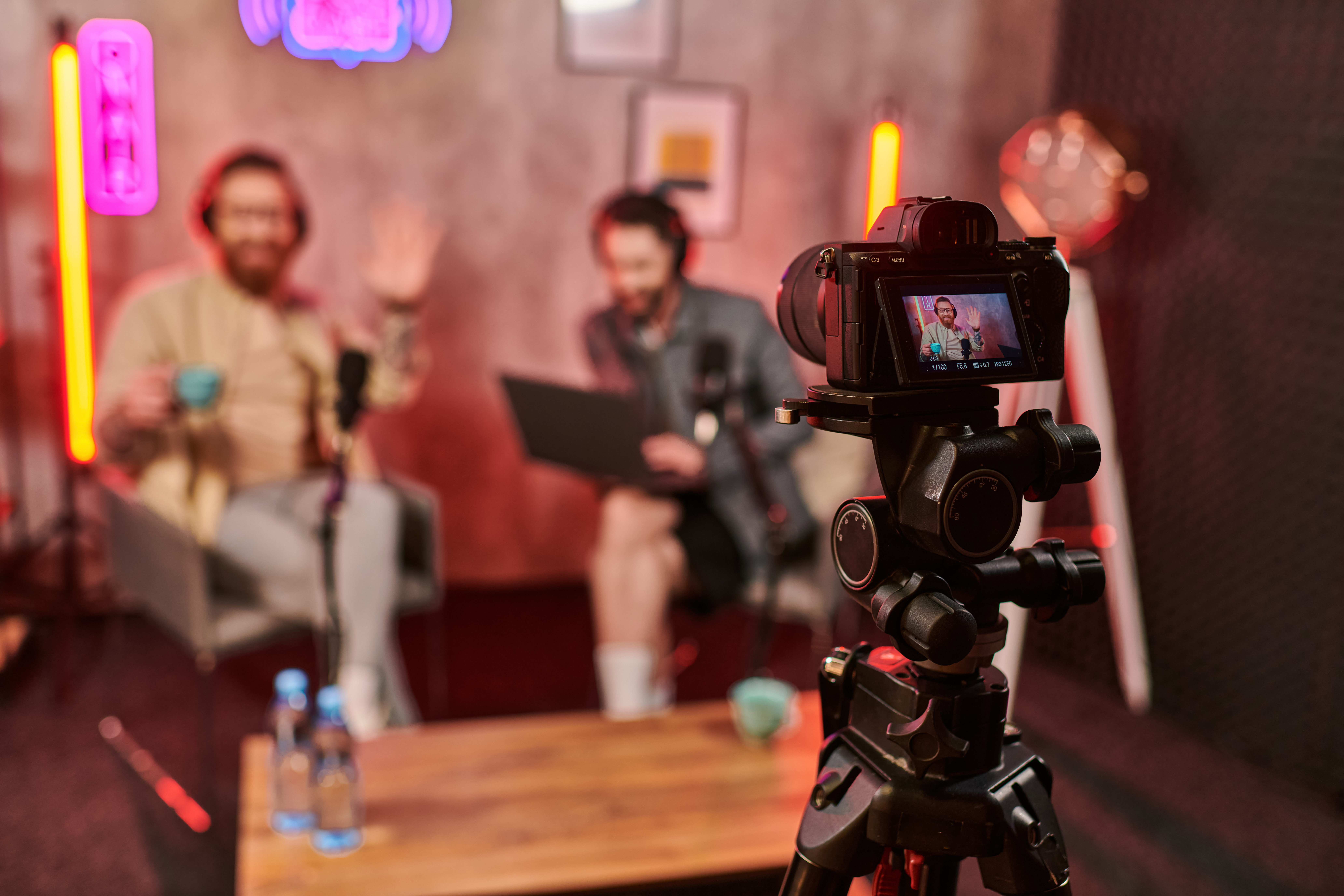 focus on camera filming stylish blurred men with beards in headphones discussing questions